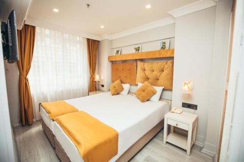 a bedroom with a large white bed with orange pillows at Just Inn Hotel in Istanbul
