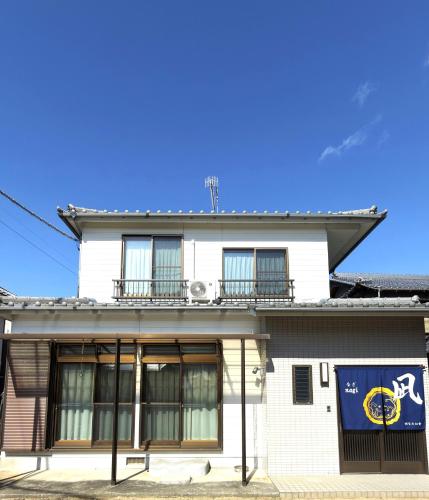 a white building with a blue sign on it at 凪 nagi Awaji in Awaji
