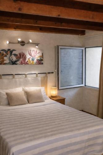 a bedroom with a large white bed and a window at Maisonnette avec piscine - sud Ardèche in Saint-Montan
