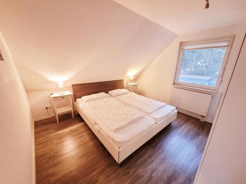 a small bedroom with a bed and a window at Haus Seeglück in Röbel