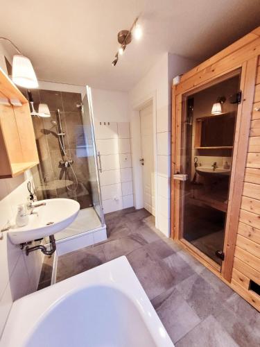 a bathroom with a tub and a sink and a shower at Haus Seeglück in Röbel