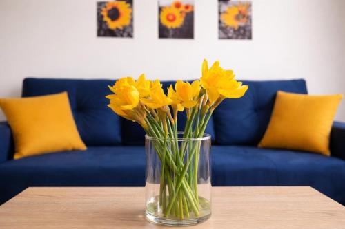 a vase of yellow flowers sitting on a table at Apartament Bałtycka Sardynka in Ustka