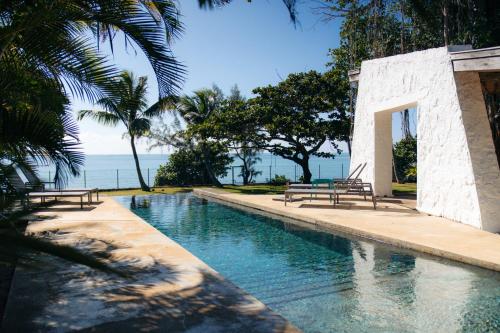 a swimming pool with two benches next to the water at Villa Opale in Trou d'Eau Douce