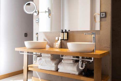 a bathroom with two sinks and towels on a table at Zenit San Sebastián in San Sebastián