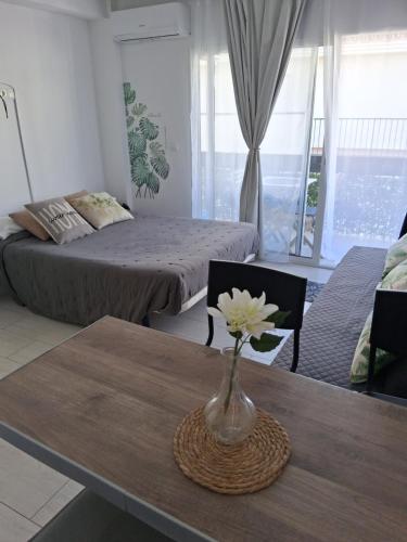 a room with a table with a vase with a flower on it at Studio with Pool BENALMADENA in Benalmádena
