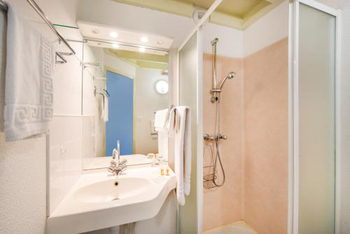 a white bathroom with a sink and a shower at LE SOUFFLE VERT in Cussac