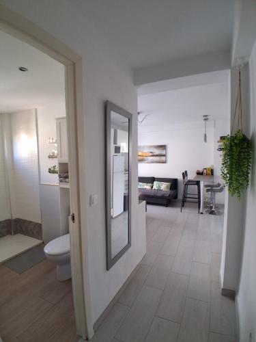 a bathroom with a toilet and a living room at Studio with Pool BENALMADENA in Benalmádena