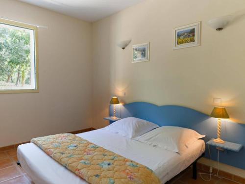 a bedroom with a bed with two lamps on two tables at Mazets Zomeno in Gaujac