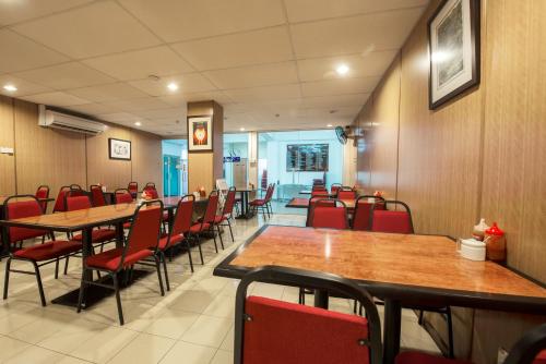 a dining room with tables and red chairs at YMCA Penang in George Town
