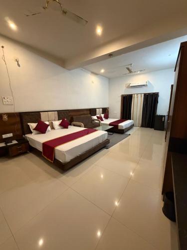 a hotel room with two beds and a couch at Silver Lake View Resort in Barhi