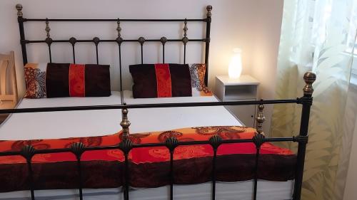 a black bed with red and black pillows at Herrmanns-Ferienhaus Wohnung 1 in Schlüsselfeld