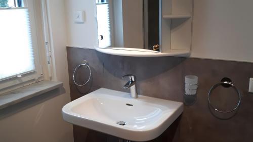 a bathroom with a white sink and a mirror at Herrmanns-Ferienhaus Wohnung 1 in Schlüsselfeld