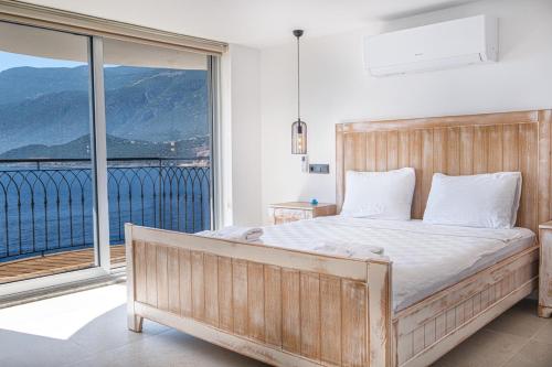 a bedroom with a large bed and a balcony at Villa Alis stunning sea view with Infinity Pool in Kaş