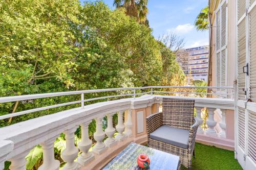a balcony with a chair and a table at Villa Claudia Hotel Cannes Centre - Parking in Cannes