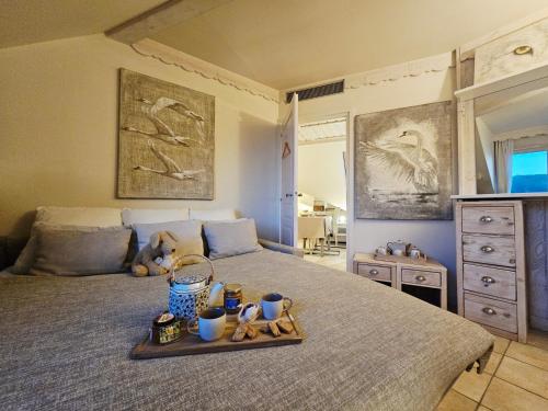 a bedroom with a bed with a tray of food on it at L'Escale au Lac - Vue panoramique - parking & plage privés in Duingt
