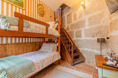 a bedroom with two bunk beds and a staircase at Casa da Avó Selene - Refúgio Rústico e Exclusivo no Douro in Favaios