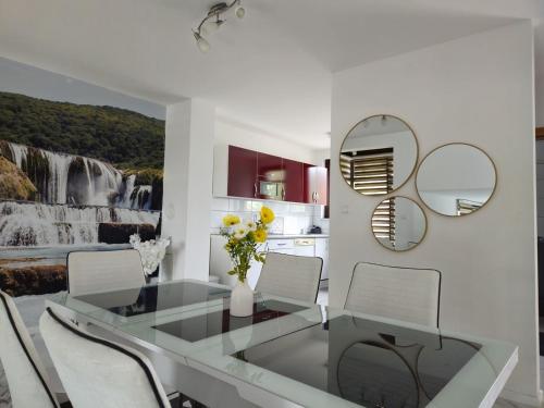 a kitchen and dining room with a waterfall painting on the wall at Villa ENT in Bihać