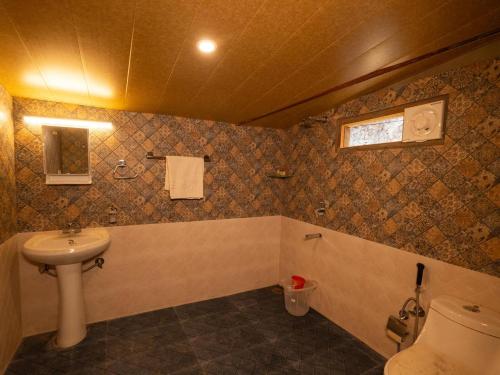 a bathroom with a sink and a toilet at Nomad Eco Retreat in Shimla