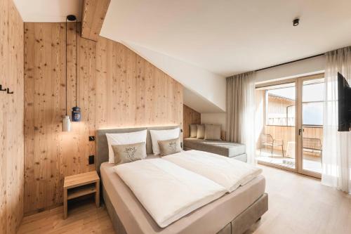 a bedroom with a large bed with a wooden wall at Wieserhof Family Farm in Maranza