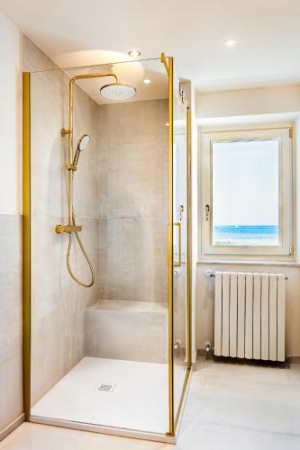 a shower with a glass door in a bathroom at Casa OliVera in Viareggio