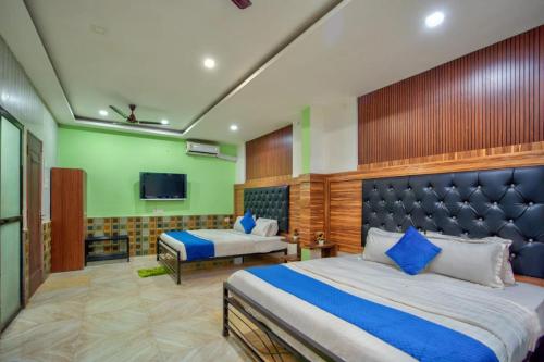 a hotel room with two beds and a tv at Calangute house inn in Calangute
