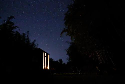 a building lit up at night with a starry sky at Bamboo Grove by Tiny Away in Bauple