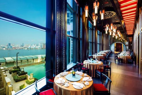 a restaurant with tables and chairs and a view of the water at Harbour Grand Hong Kong in Hong Kong