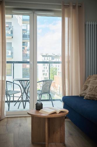 a room with a bed and a table with a book at Symphony City Square Aparthotel by INA in Wrocław