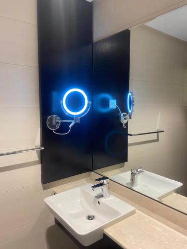 a bathroom with a white sink and a mirror at Abdali Views Luxury Suite in Al Jafr