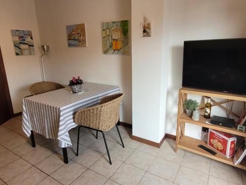 a dining room table with chairs and a television at Blue Lake in Acquaseria