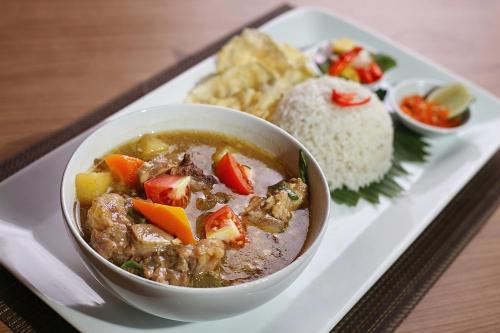 a plate of food with a bowl of soup and rice at Horison Tasikmalaya in Tasikmalaya