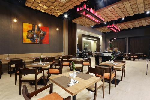 a dining room with tables and chairs and a restaurant at Horison Tasikmalaya in Tasikmalaya