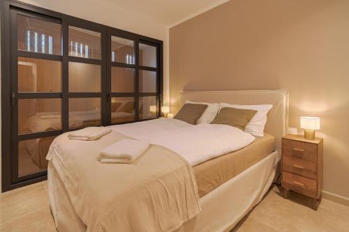 a bedroom with a large white bed with a window at Stadthaus mit Garten und Dachterrasse -Casa Villanova in Pollença