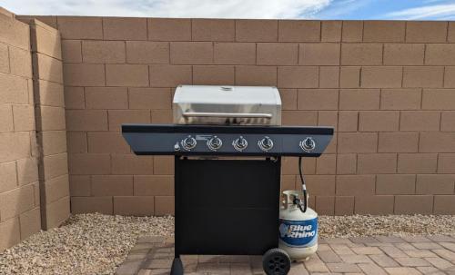 a barbecue grill with a drink next to a wall at Cozy Southwest Style Hideaway with Mountain Views in Phoenix