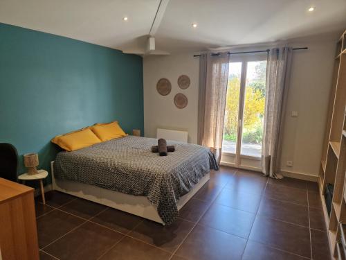 a bedroom with a bed and a large window at Maison Montellier - piscine in Charly