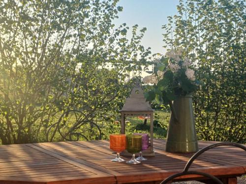 a wooden table with two glasses and a vase at Gîte Domaine St Georges in Bagneux