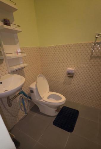 a bathroom with a toilet and a sink at Restaurant Mayuree in Kranuan