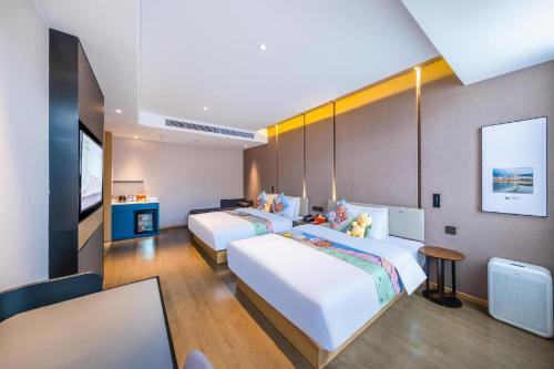 a hotel room with two beds and a television at Atour Hotel Kunming Cuihu in Kunming