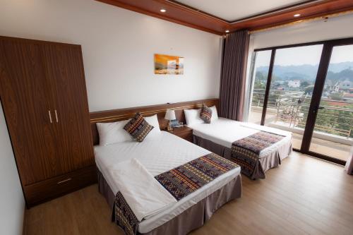 a hotel room with two beds and a large window at Mộc View House in Mộc Châu