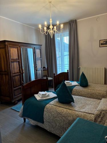 a hotel room with two beds and a chandelier at BRAIDE Ospitalità Rurale in La Morra