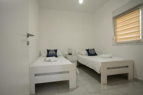 a bedroom with two beds and a cross on the wall at Natura Apartmani in Ljubuški
