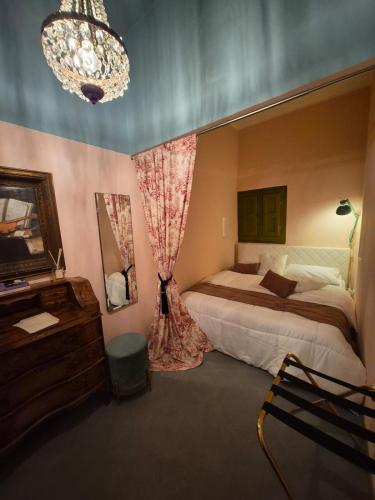 a bedroom with a bed and a chandelier at Vicolo Re suite in centro con stile in Porto Empedocle