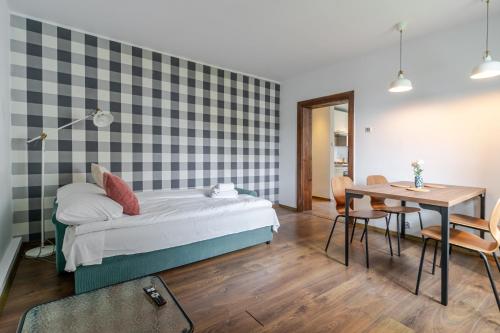 a bedroom with a bed and a table with chairs at Mastalerza Spacious Apartment by BookingHost in Gliwice