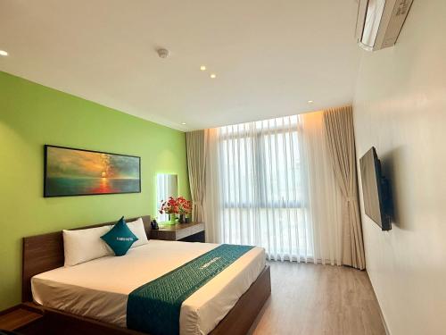 a bedroom with a bed and a green wall at Khách sạn XMen Thanh Hóa - Không gần biển in Thanh Hóa