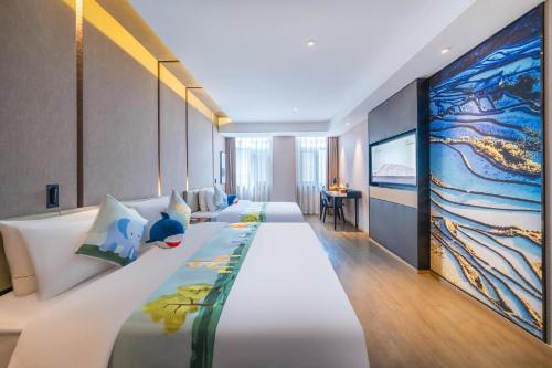 a hotel room with two beds and a tv at Atour Hotel Kunming Cuihu in Kunming