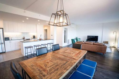 a kitchen and living room with a wooden table and chairs at 310 - Luxury Condo The Serenity - View and Pool in Baie-Saint-Paul