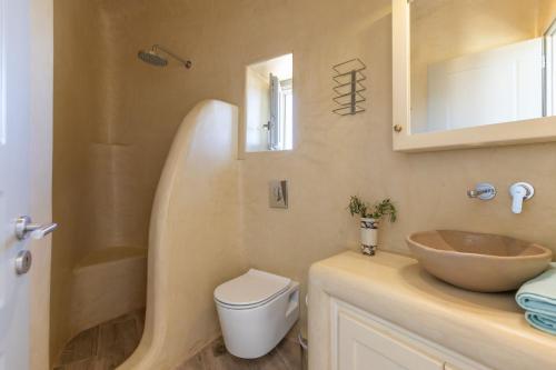 a bathroom with a sink and a toilet and a mirror at Casa Elena in Aggelika
