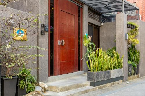 a red door on the side of a building with plants at 傅棧 Fu Yu in Tainan
