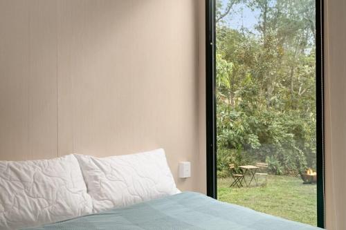 a bedroom with a bed and a window with a view at Natural Age by Tiny Away in Bahrs Scrub