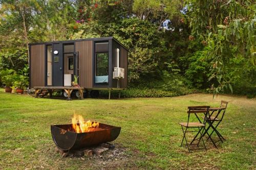 a tiny house with a fire pit in a yard at Natural Age by Tiny Away in Bahrs Scrub